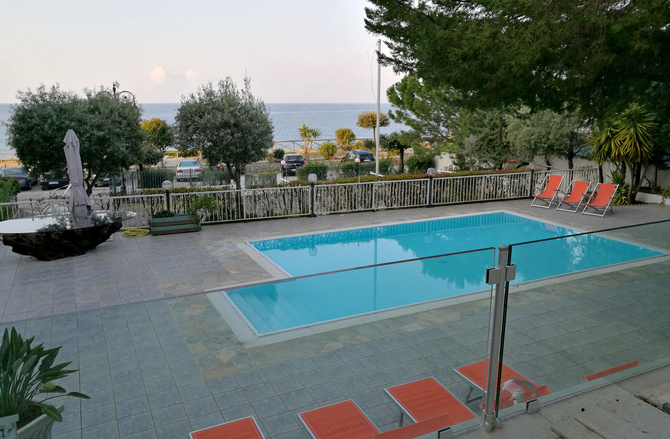 Blick von der Terrasse mit Olivenbäumen auf den Pool